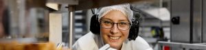 Woman in protective clothing conducting an internal food safety gap audit